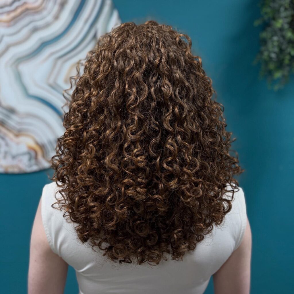 Krullend haar wordt droog geknipt tijdens een professionele curly cut